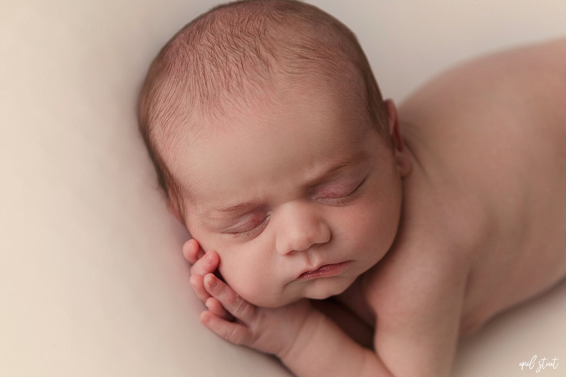 baby laying on side on white classic backdrop photographer April Stout near Jenks Oklahoma