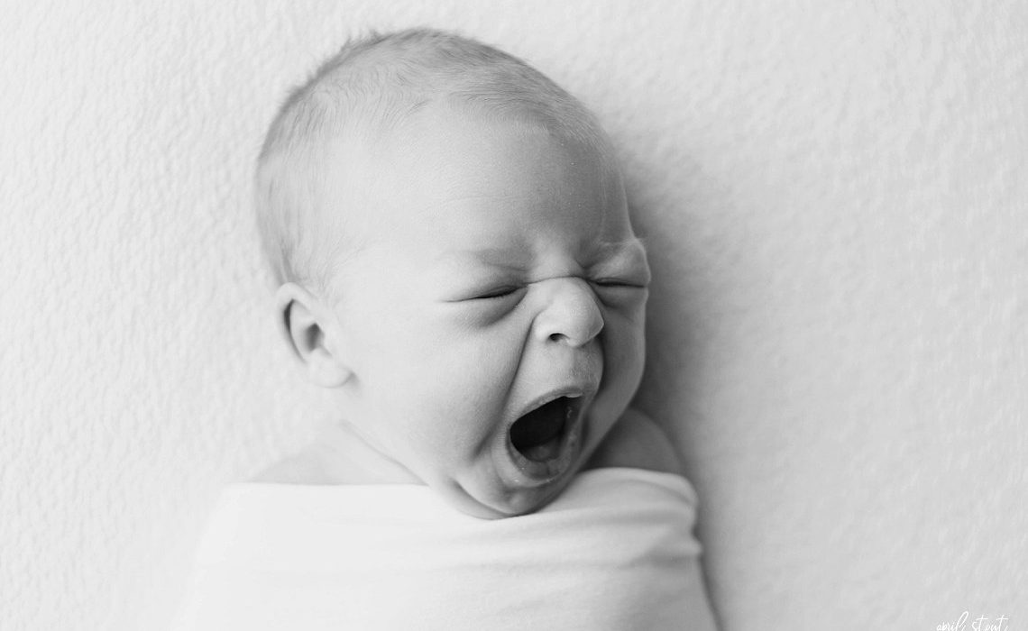 new baby boy on simple white backdrop by April Stout Photography Tulsa Oklahoma